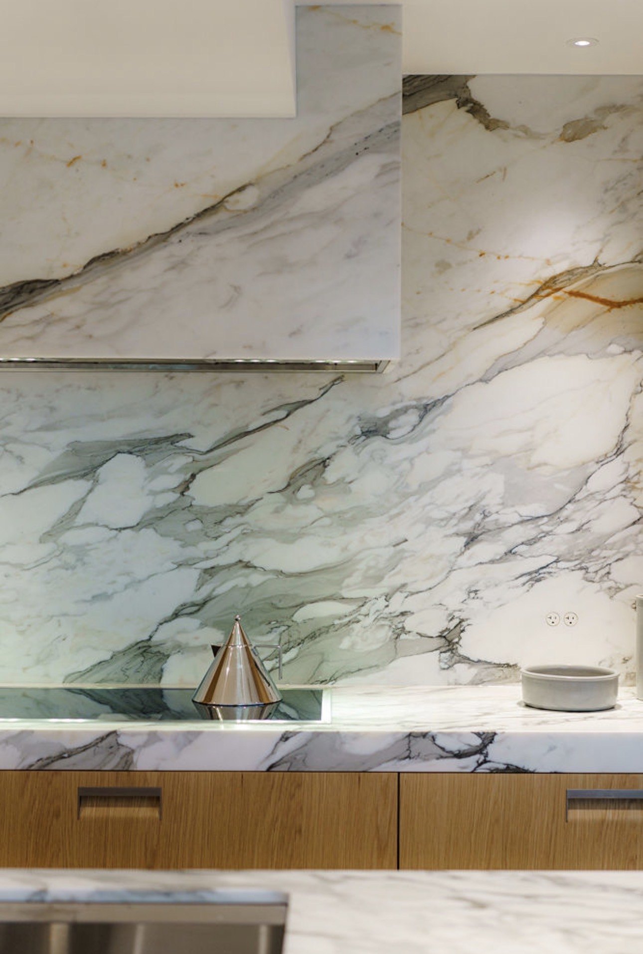 Hornby, full height book matched marble slab backsplash above the range and counter, built by Burj Enterprises